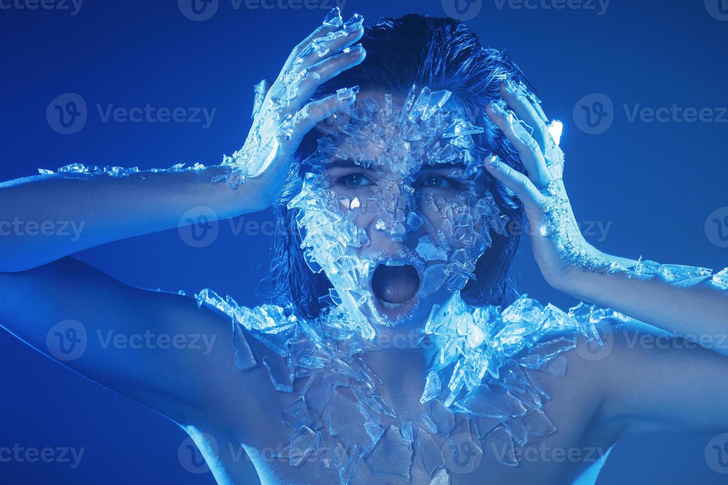 Female face covered with a lot small pieces of glass or ice photo