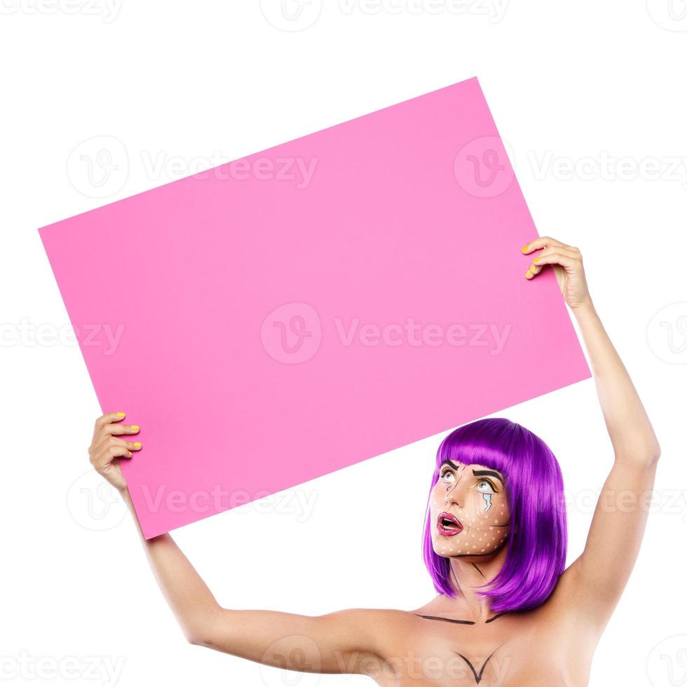 Model in creative image with pop art makeup is holding pink blank board photo