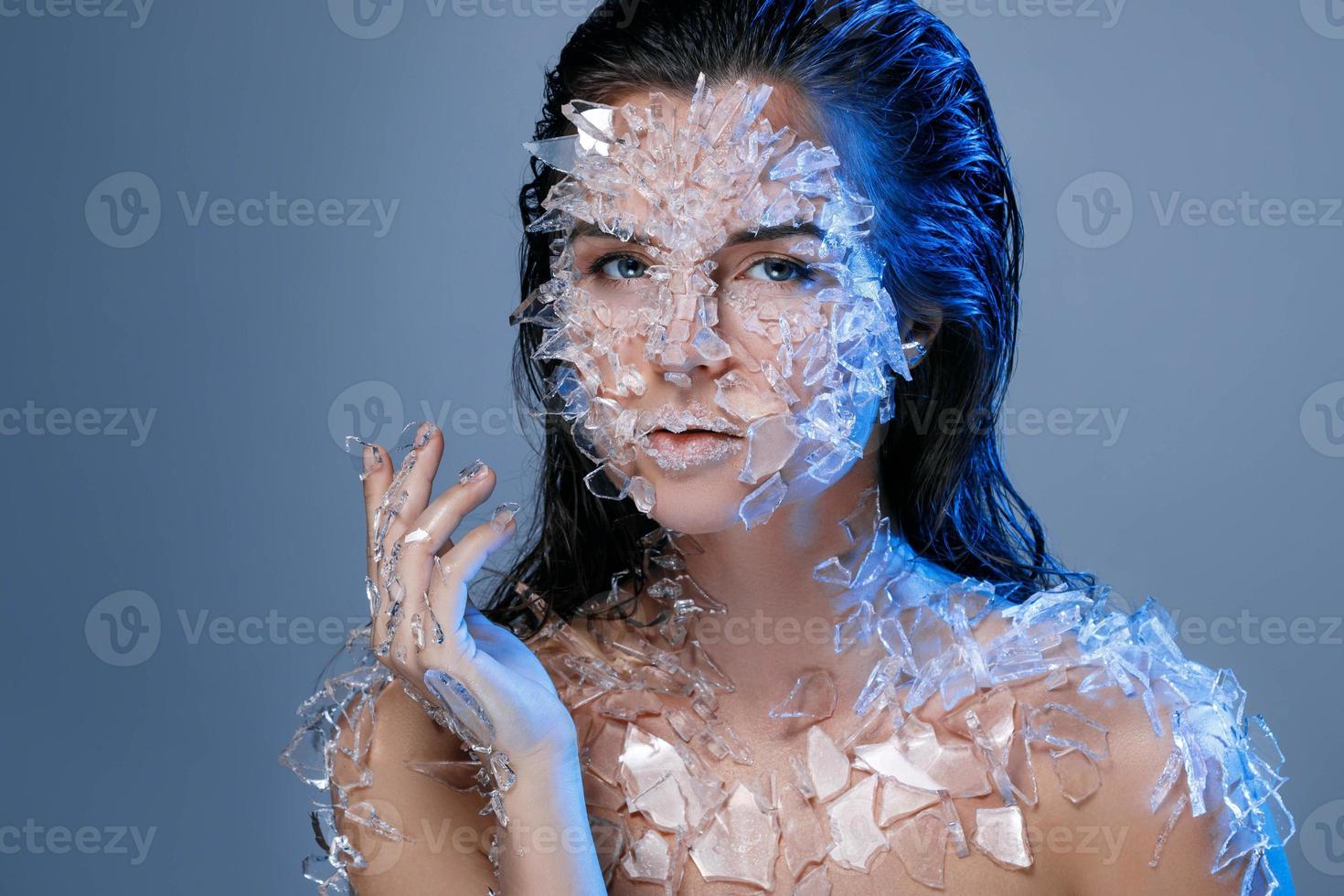 Female face covered with a lot small pieces of glass or ice photo