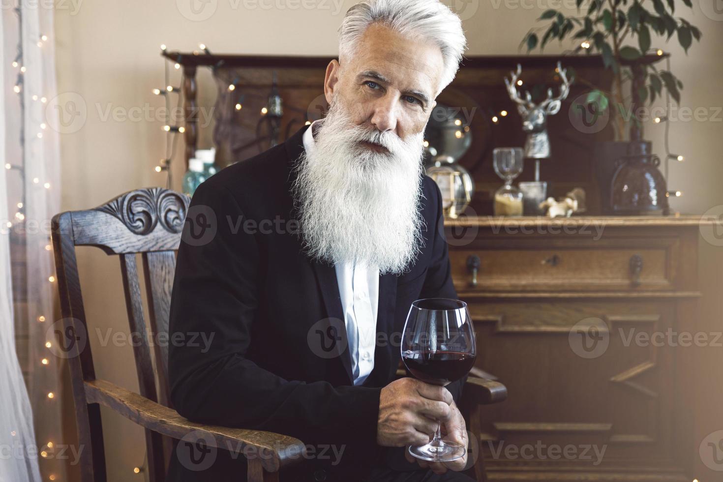 Handsome bearded senior man drinking red wine photo