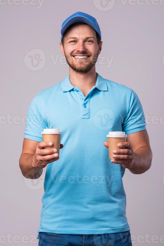 Happy delivery man with a two cups of coffee photo