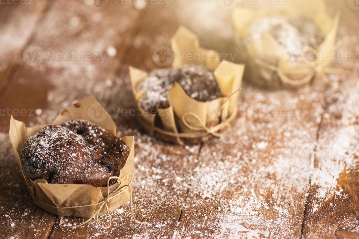 Cooking tasty chocolate muffins in powdered sugar photo