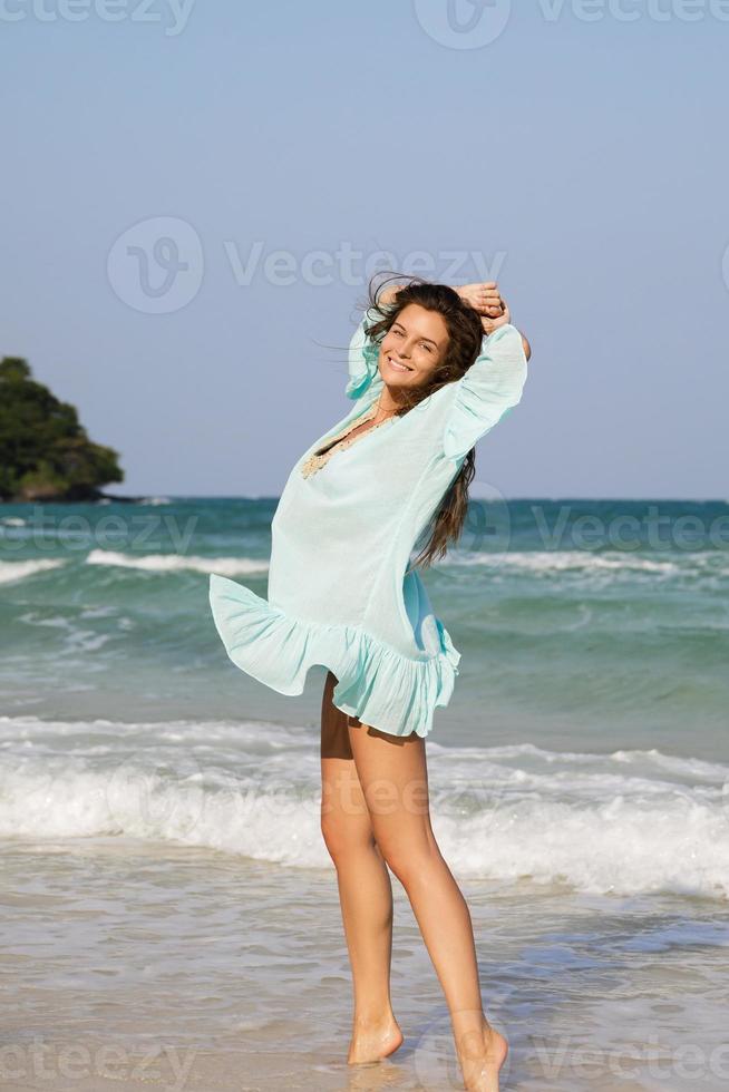 Young lovely woman is walking by the sea shore photo