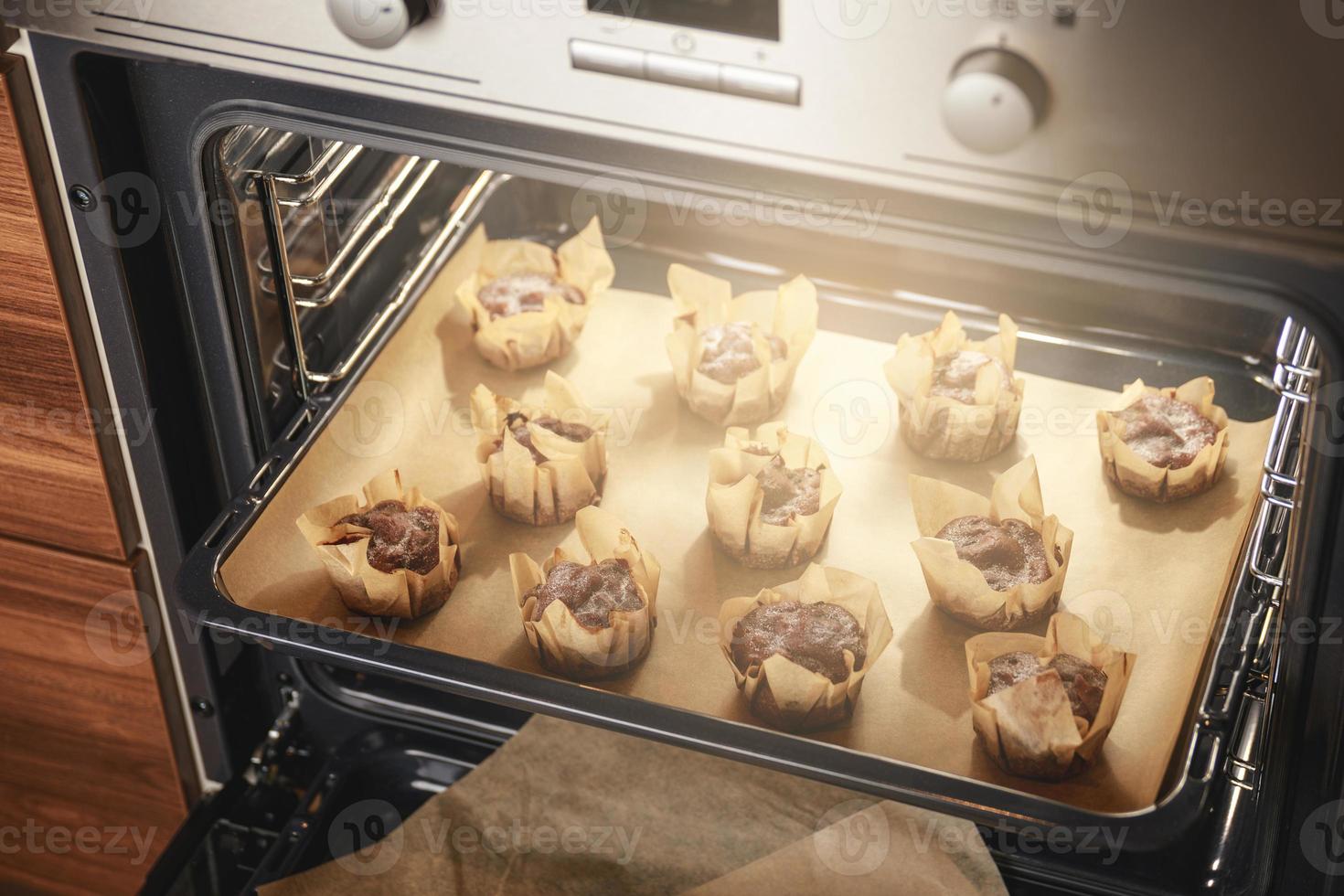 Cooking tasty sweet muffins in the oven photo