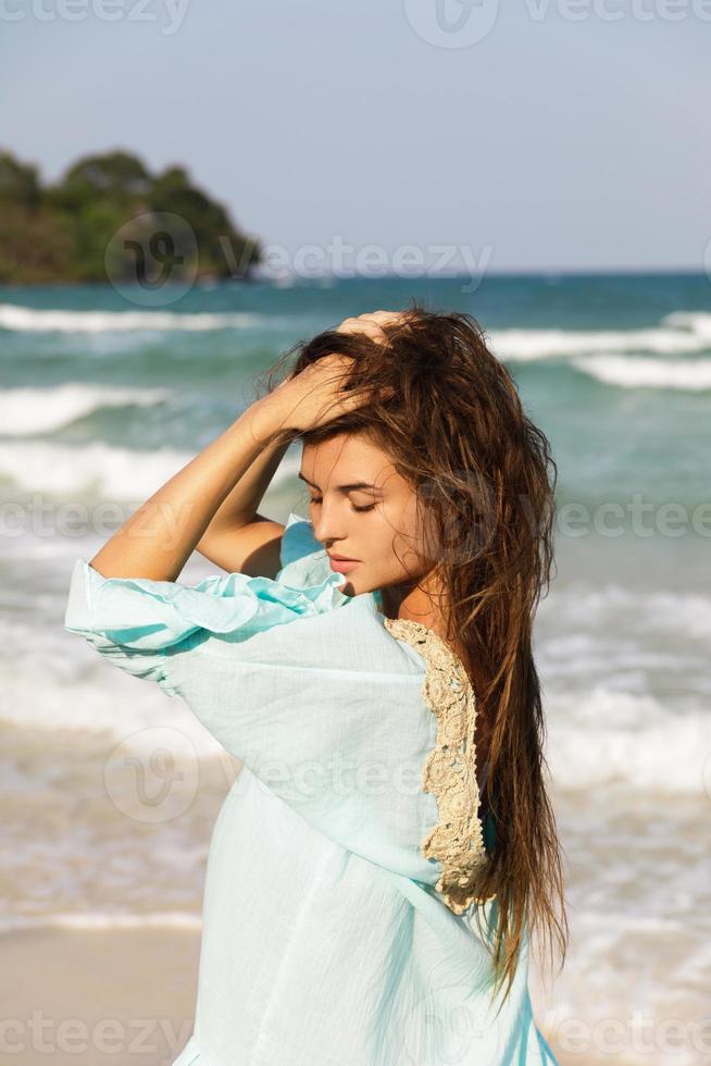 Young lovely woman is walking by the sea shore photo