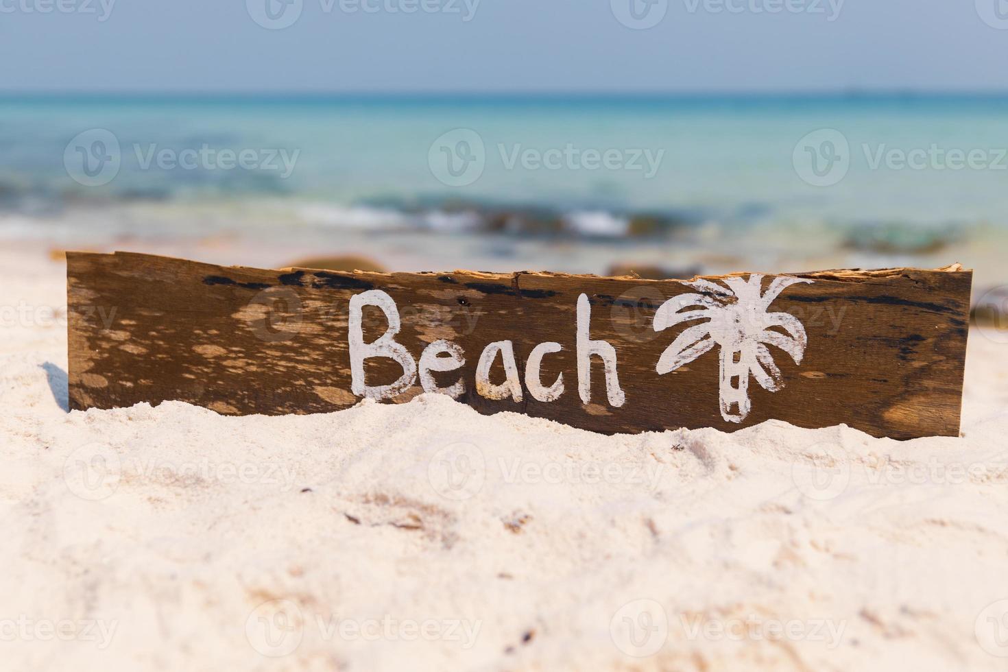 Wooden sign with lettering on the beach photo