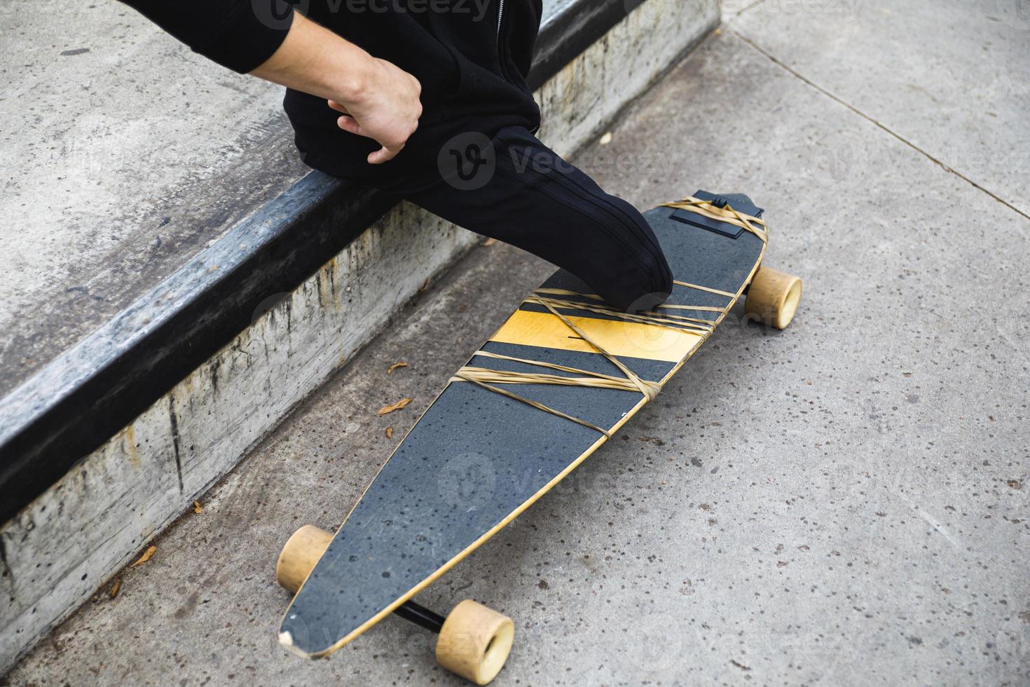 Handicapped young guy with a longboard in park photo