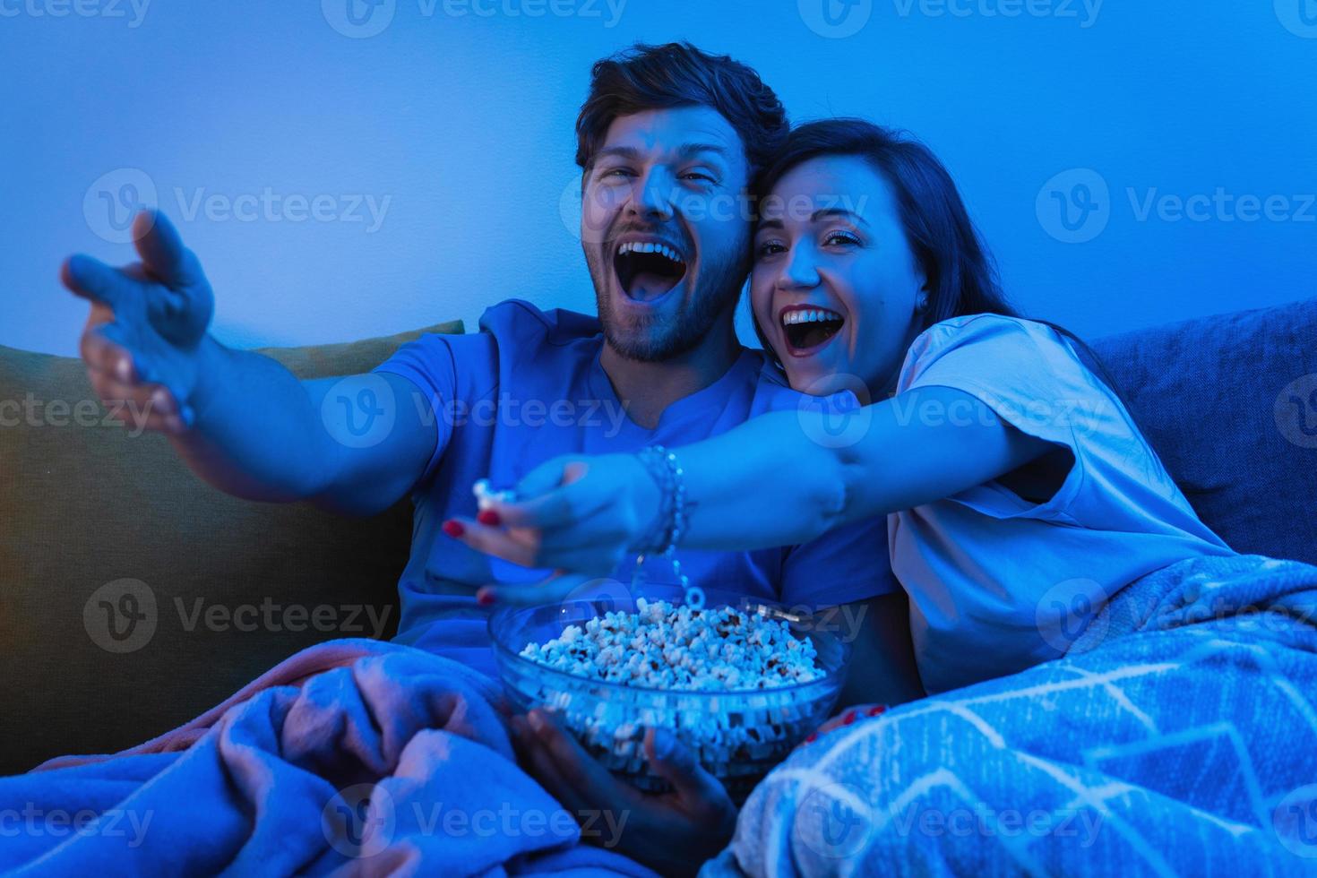 pareja joven y feliz viendo un programa de televisión de comedia foto