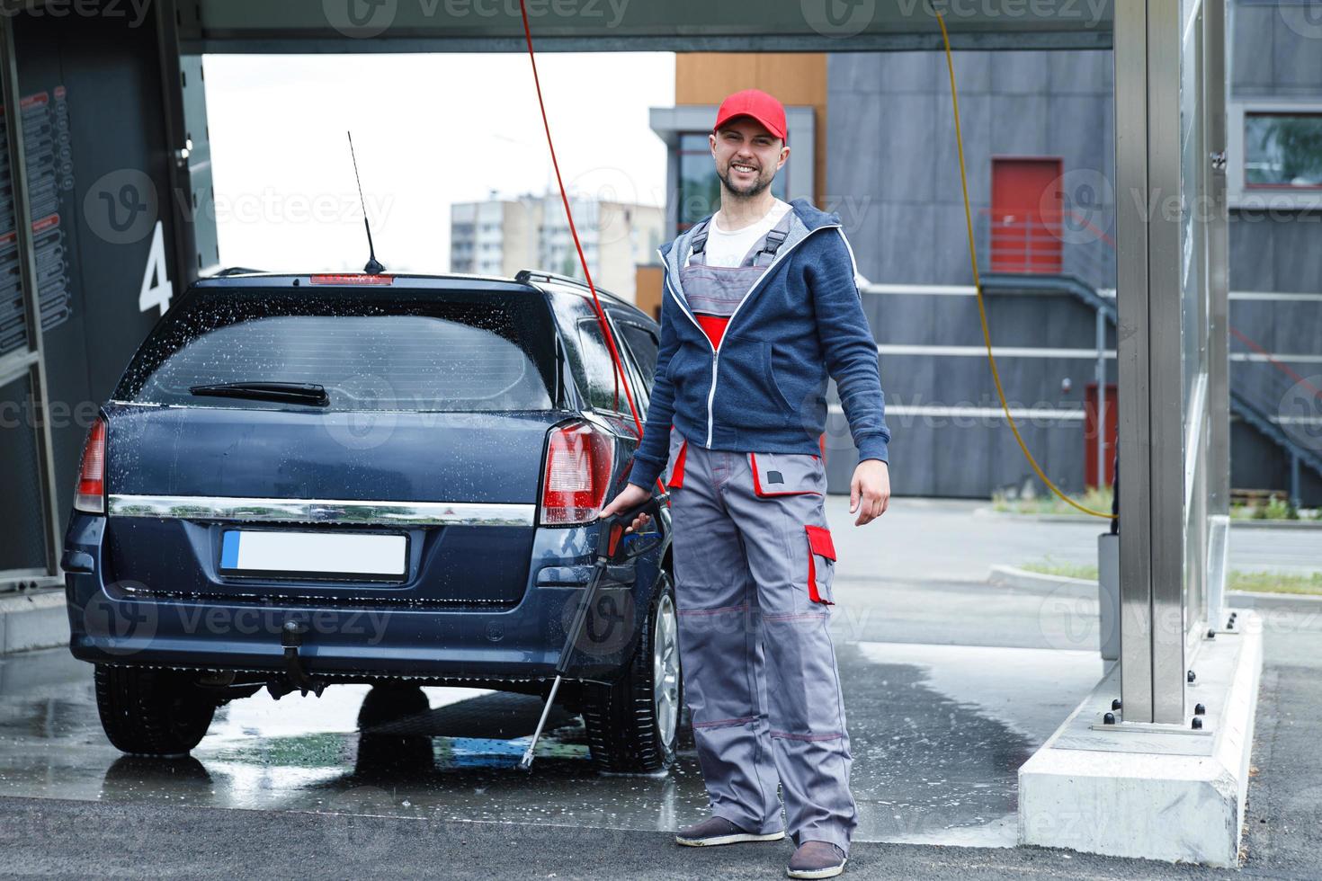 Car wash worker is washing client's car photo
