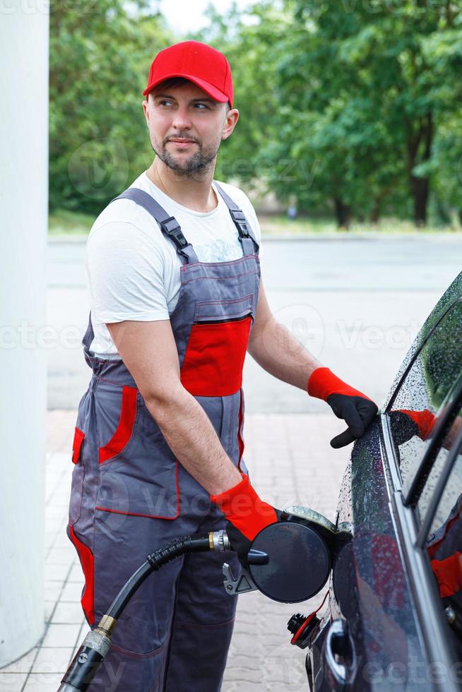 Filling station attendant filling tank of clients car photo