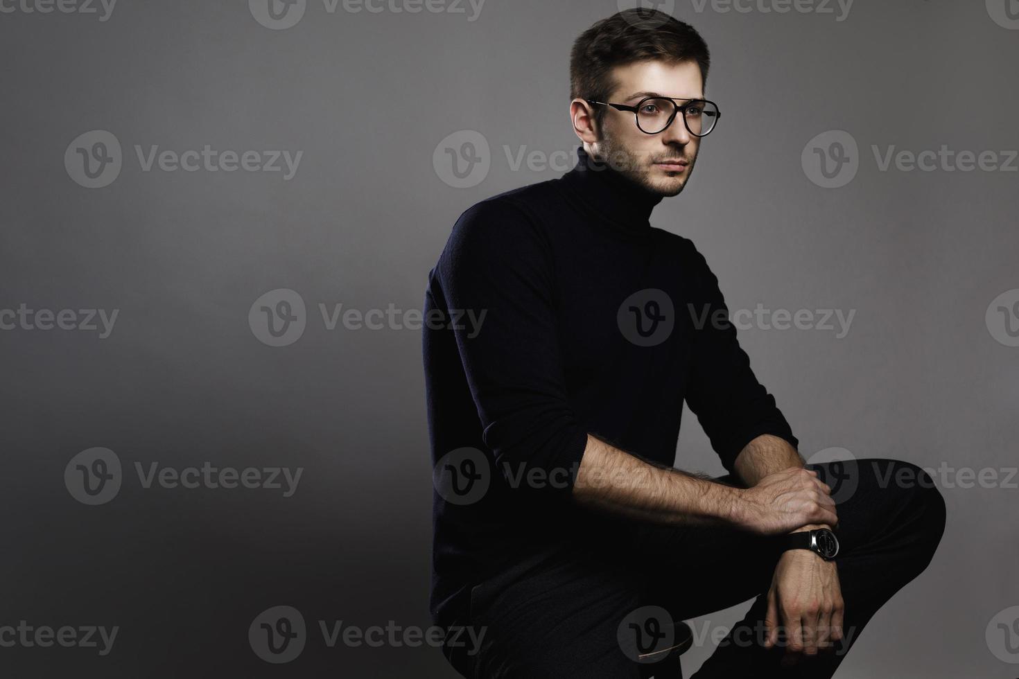 Young smart man wearing glasses and a folded polo neck photo