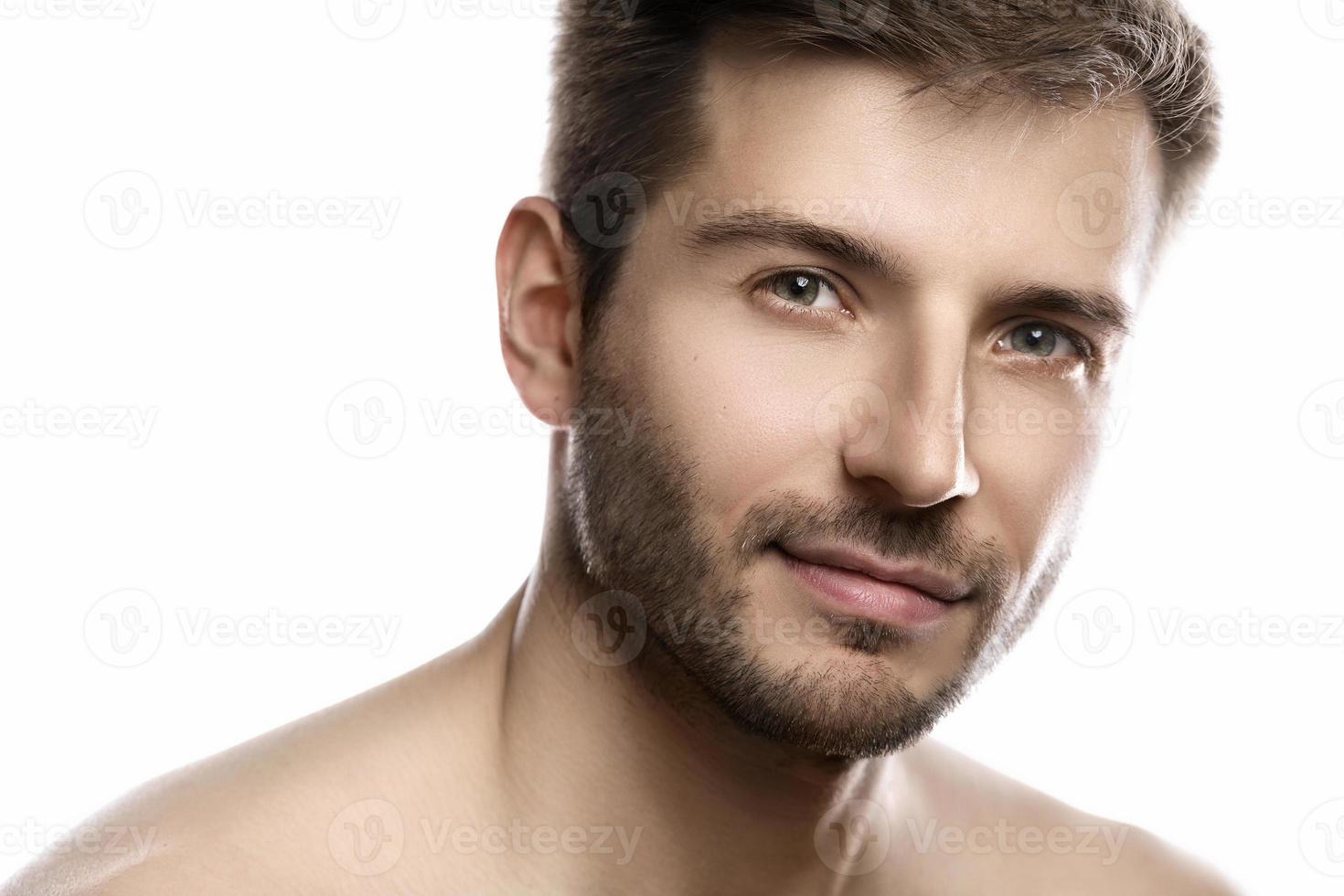 Young and handsome man with smooth skin on white background photo