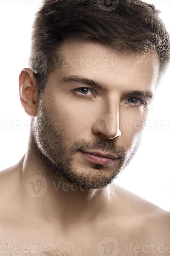 hombre joven y guapo con piel suave sobre fondo blanco foto