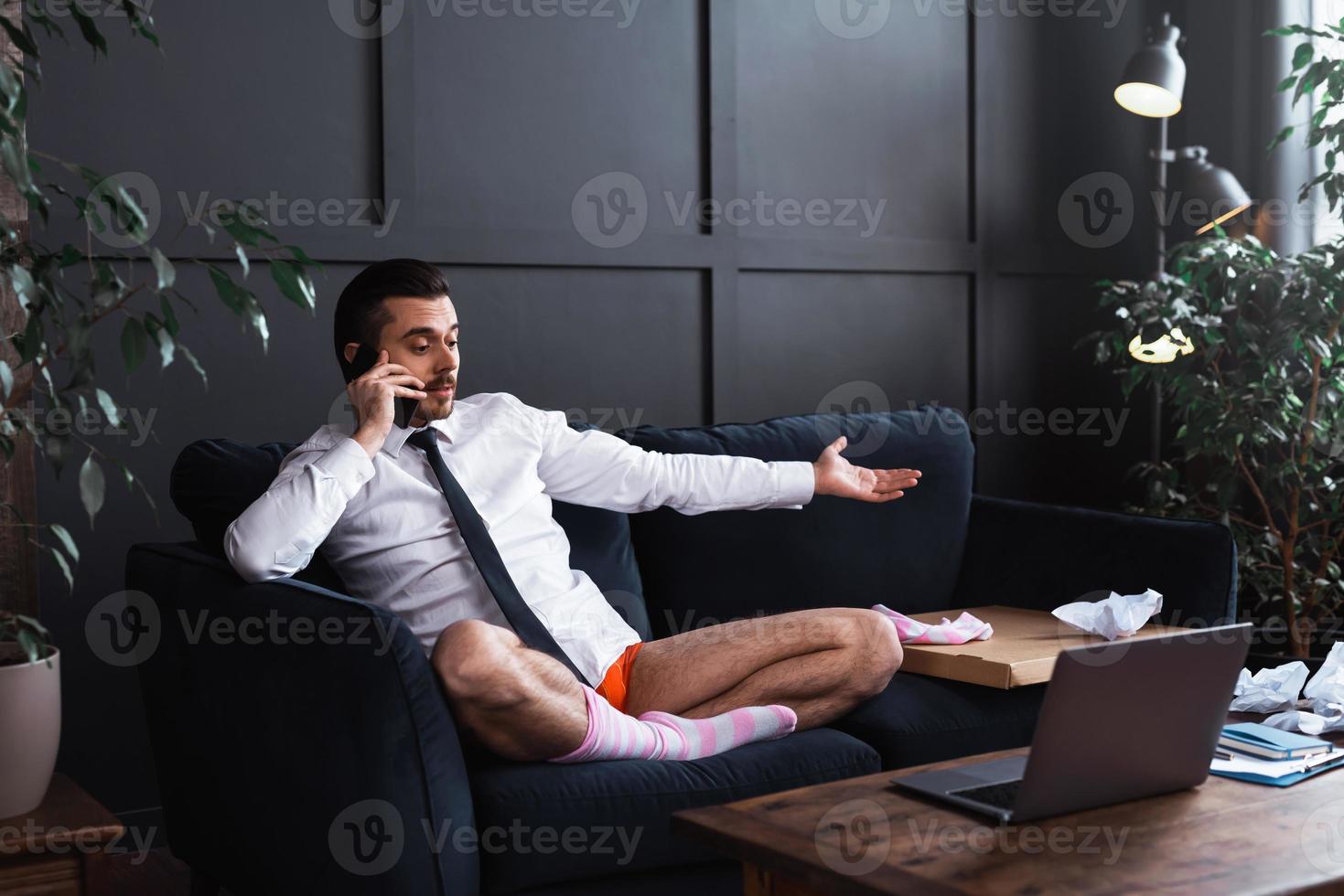 Lazy businessman without pants working from home photo