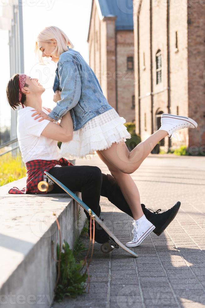 Teenage couple with a longboard during their date in a city photo