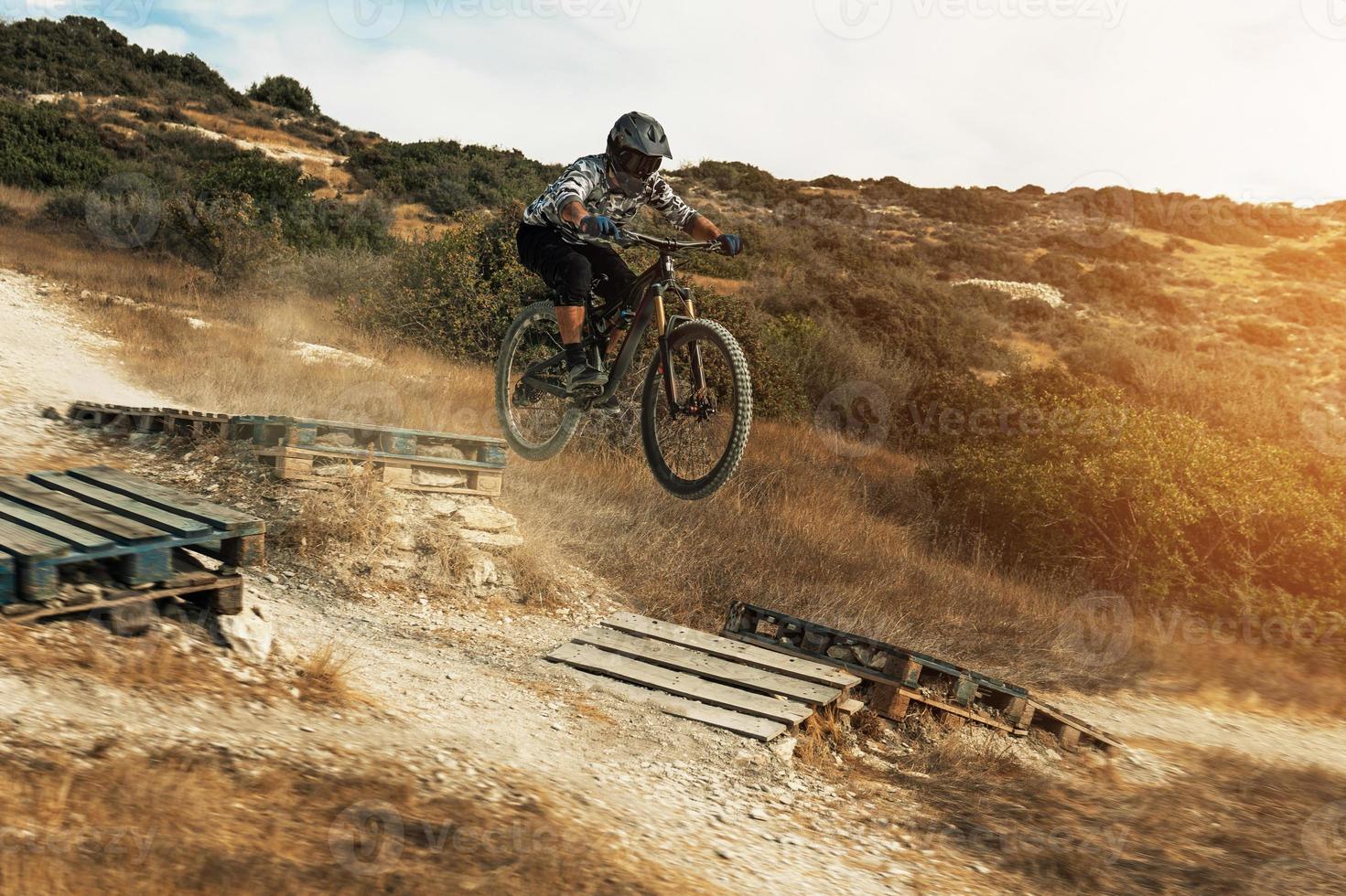 MTB bike rider jumping during downhill ride on his bicycle in mountains photo