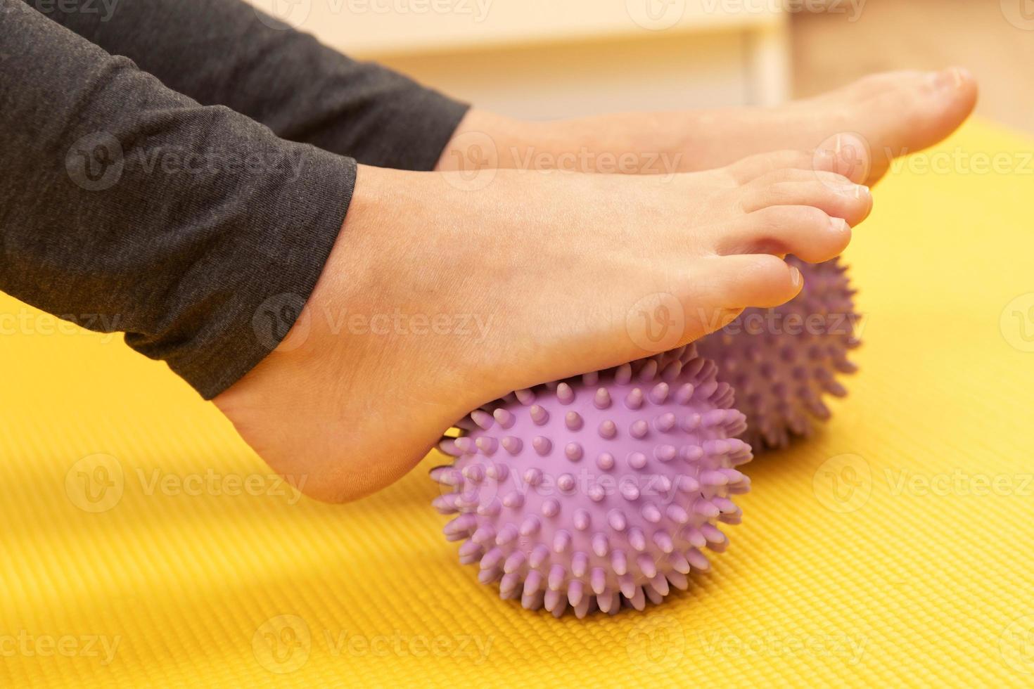 pies femeninos y bolas de masaje espinosas moradas foto