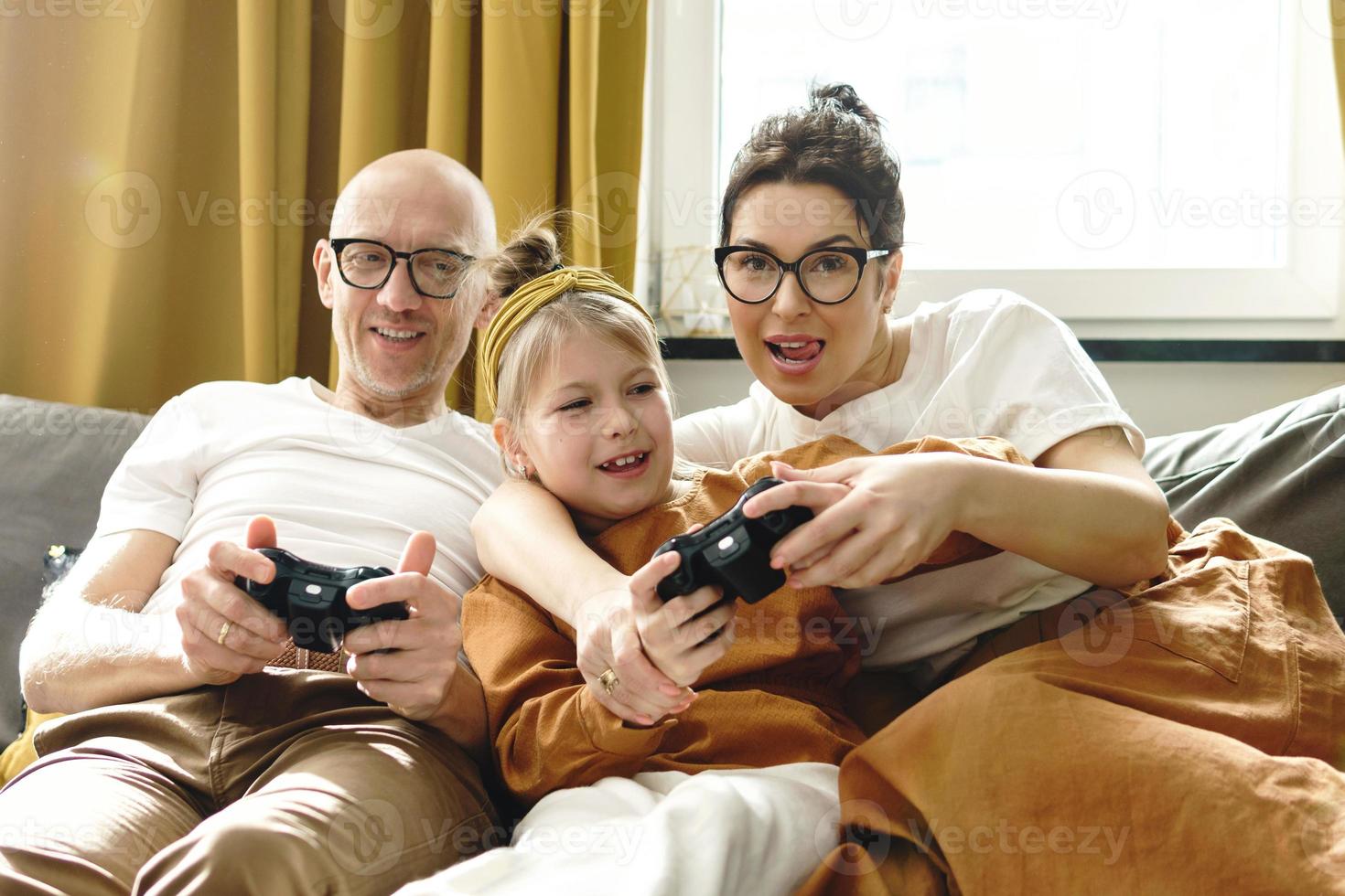 Happy family is playing video game console at home photo