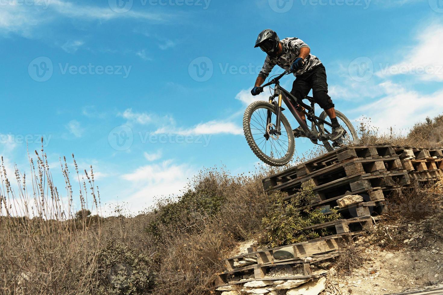 MTB bike rider jumping during downhill ride on his bicycle in mountains photo