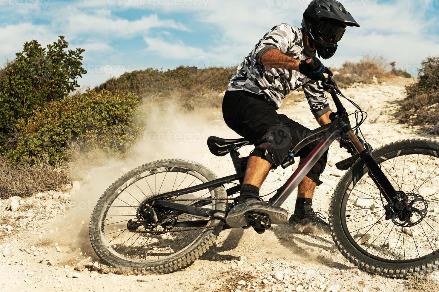 Professional bike rider during downhill ride on his bicycle photo