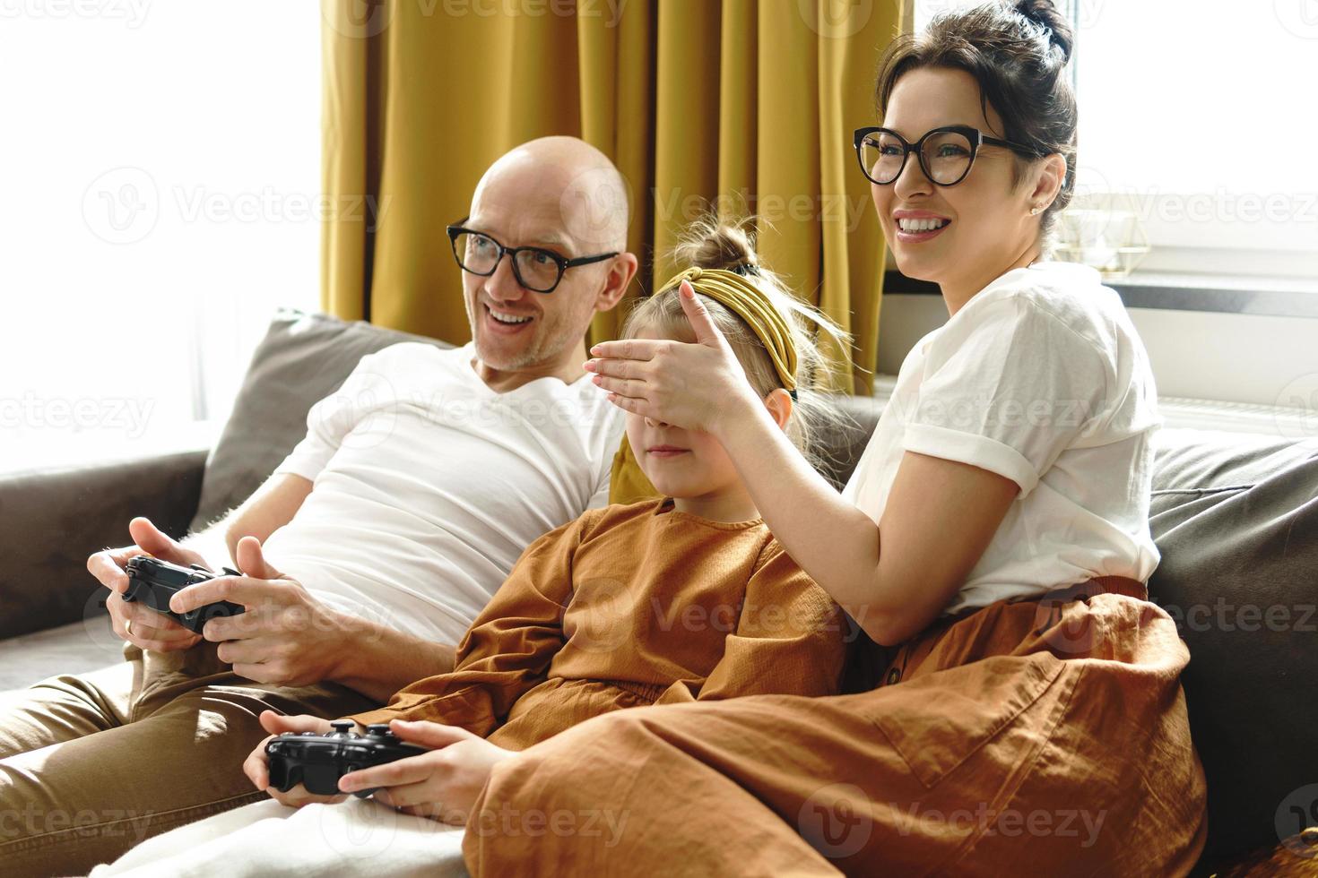 Happy family is playing video game console at home photo