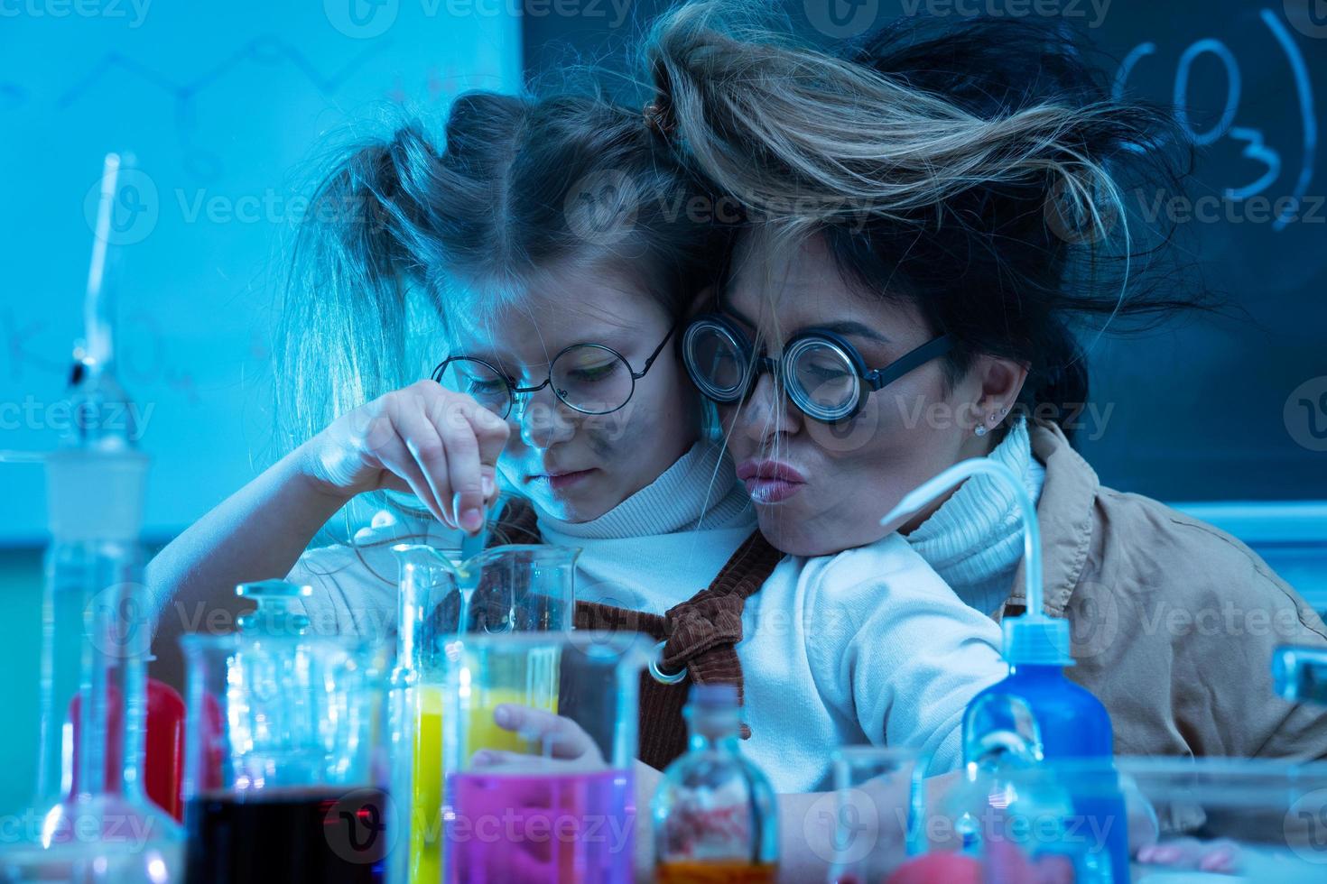 profesor y niña durante la lección de química mezclando productos químicos en un laboratorio foto