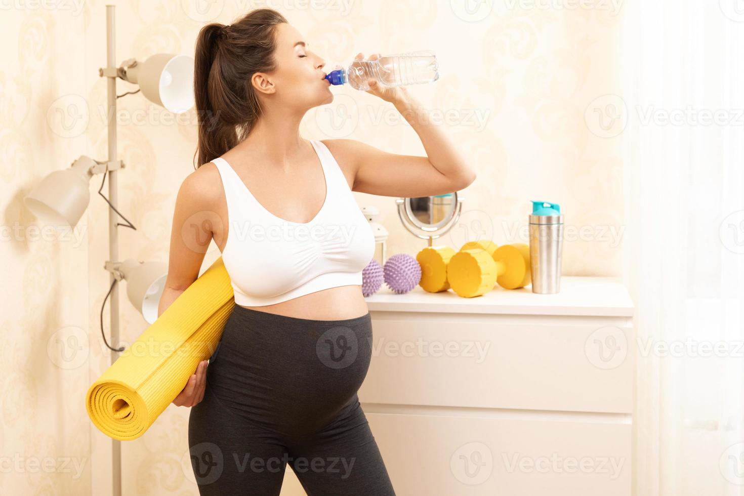 Pregnant woman during her fitness workout at home photo