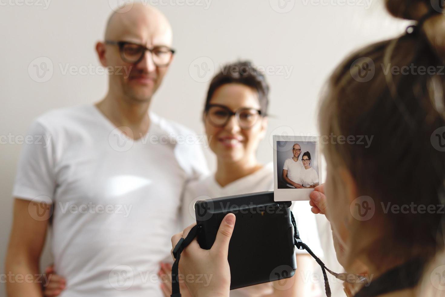 Girl made a photo of her parents with a instant camera