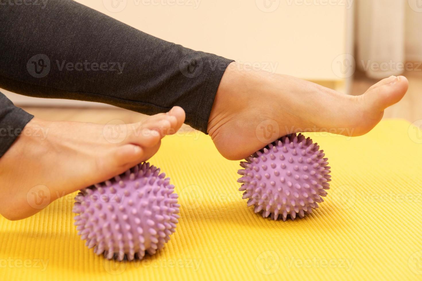 pies femeninos y bolas de masaje espinosas moradas foto