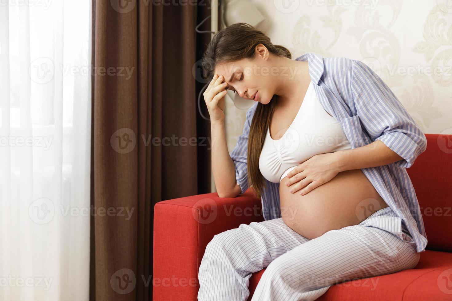 Young and pregnant woman at home feels sick photo