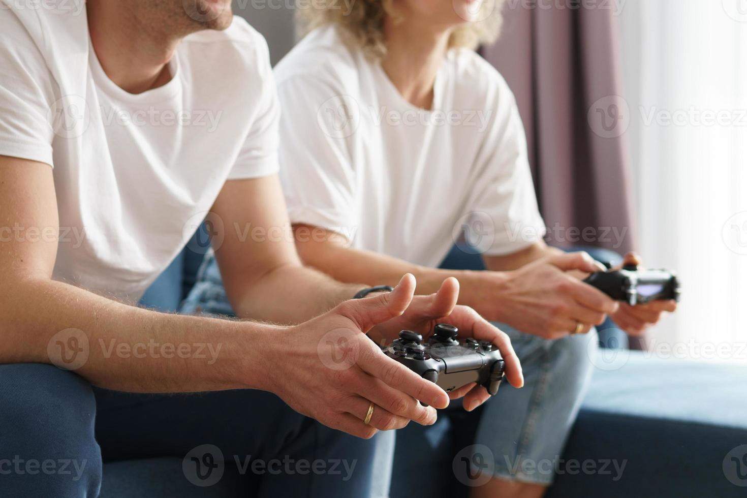 Couple with a gamepads are playing video game console photo