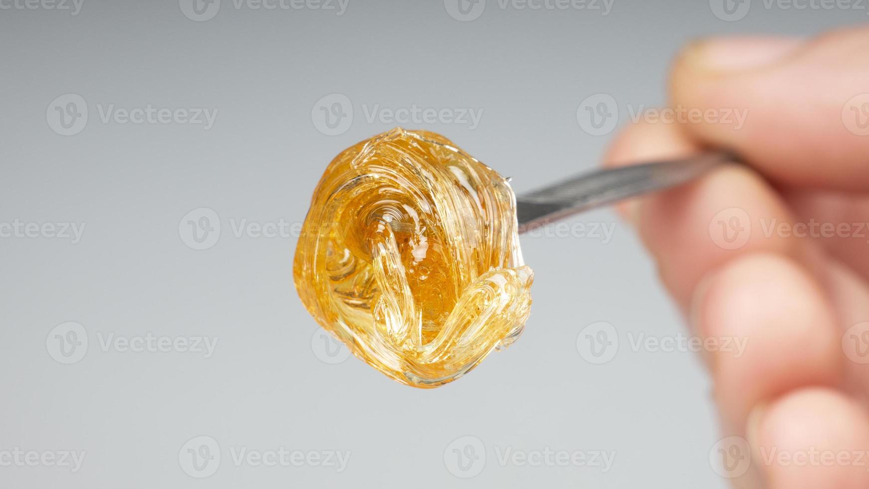 yellow resin extract on dab stick tool closeup, gold  wax smear for stoner smoke photo