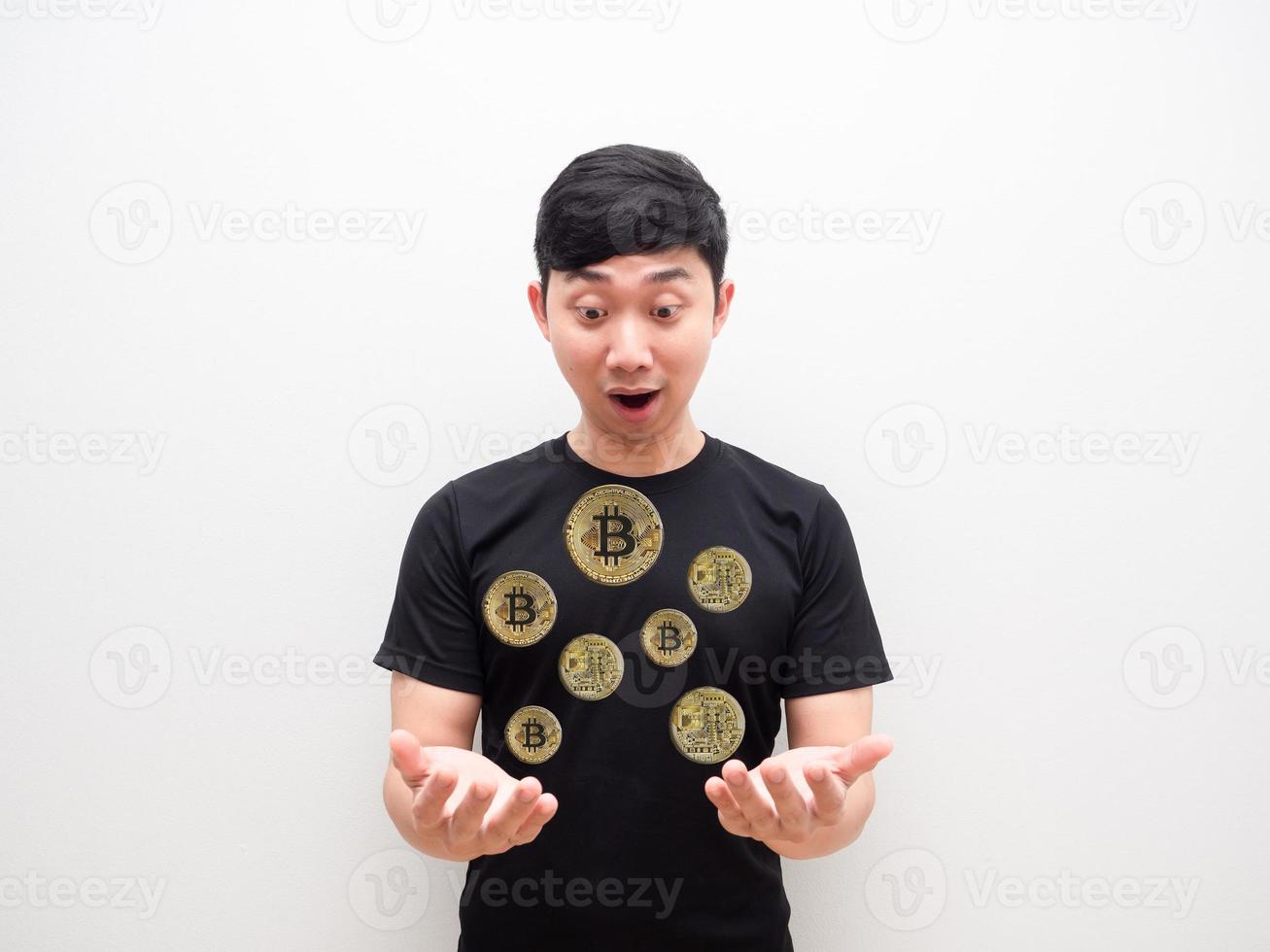 un hombre asiático que mira muchos bitcoins en dos manos se siente emocionado y se enfrenta al concepto de dinero digital en un fondo blanco aislado foto