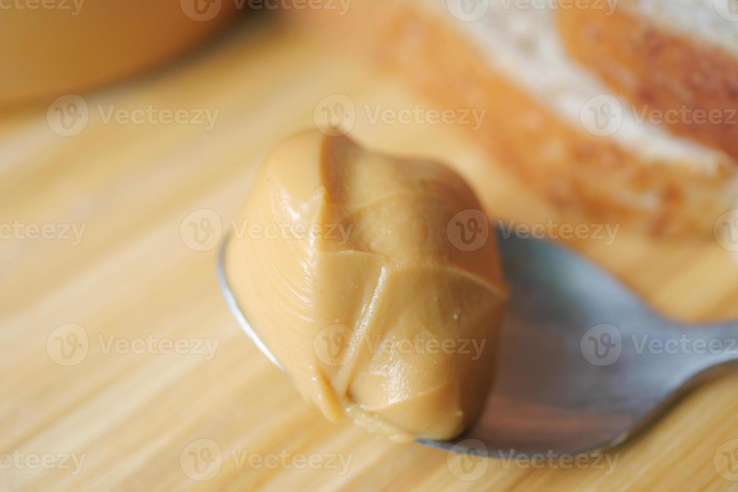 Cerca de mantequilla de maní en una cuchara en la mesa foto