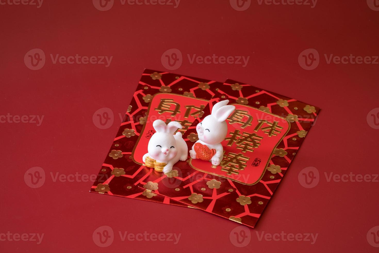 Chinese New Year of the rabbit festival concept. Rabbit on red envelopes isolated on red background. Happy New Year Chinese Rabbit 2023. Chinese characters means rich, wealthy, healthy and happy. photo