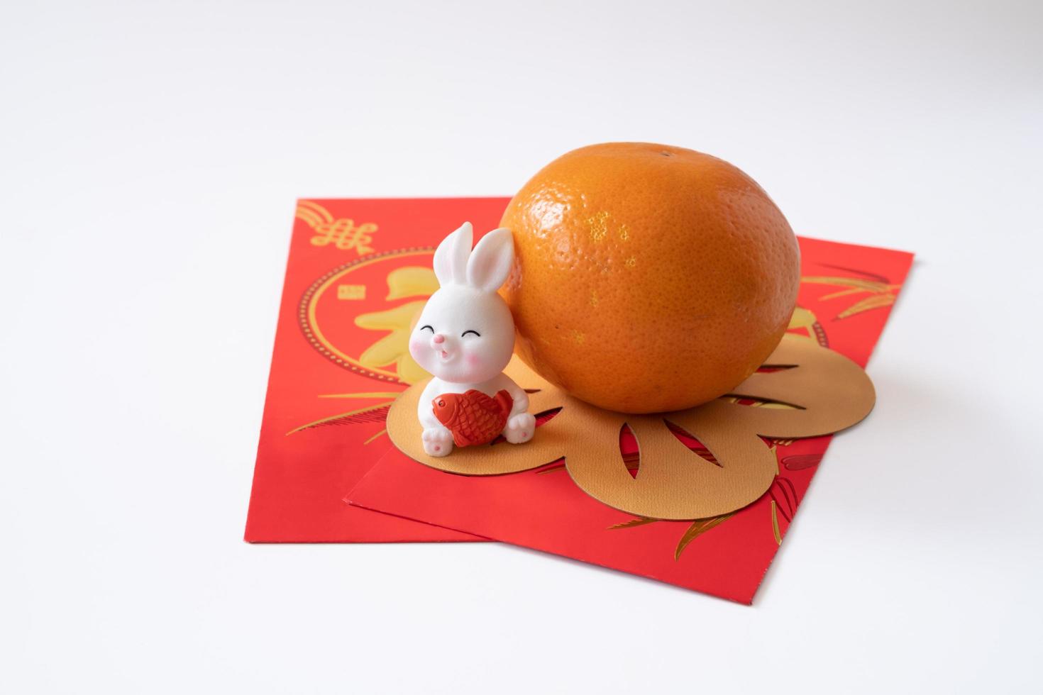 Chinese New Year of the rabbit festival concept. Mandarin orange,  rabbit and gold ingot isolated on white background. photo