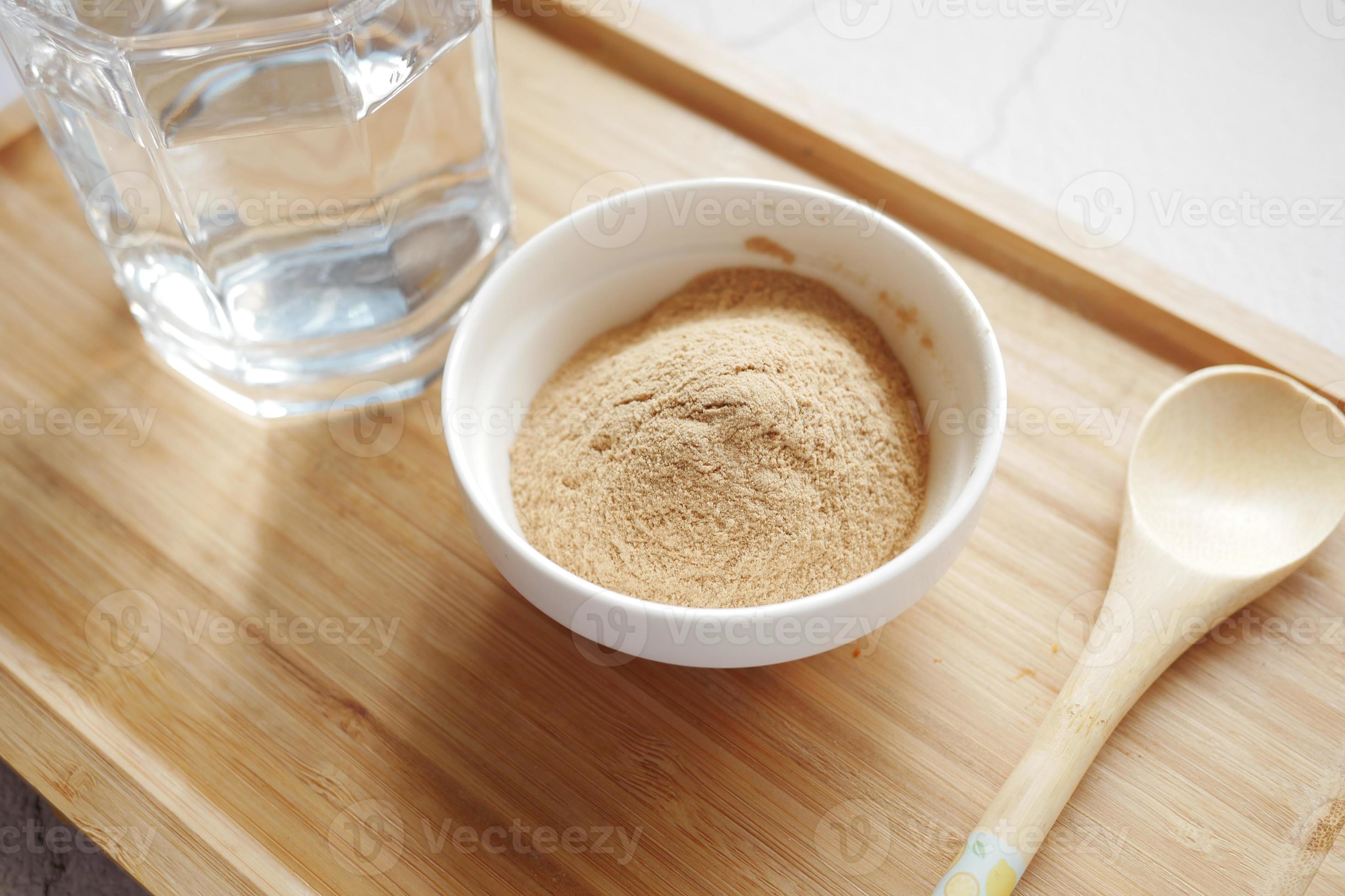 mixing brewers yeast flakes in a glass of water 16243435 Stock Photo at