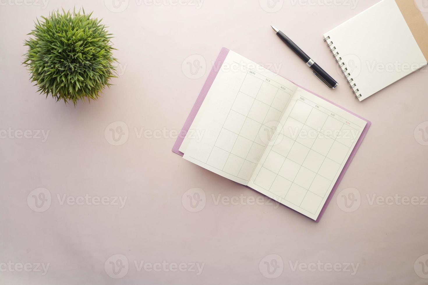 weekly planner and notepad on table photo