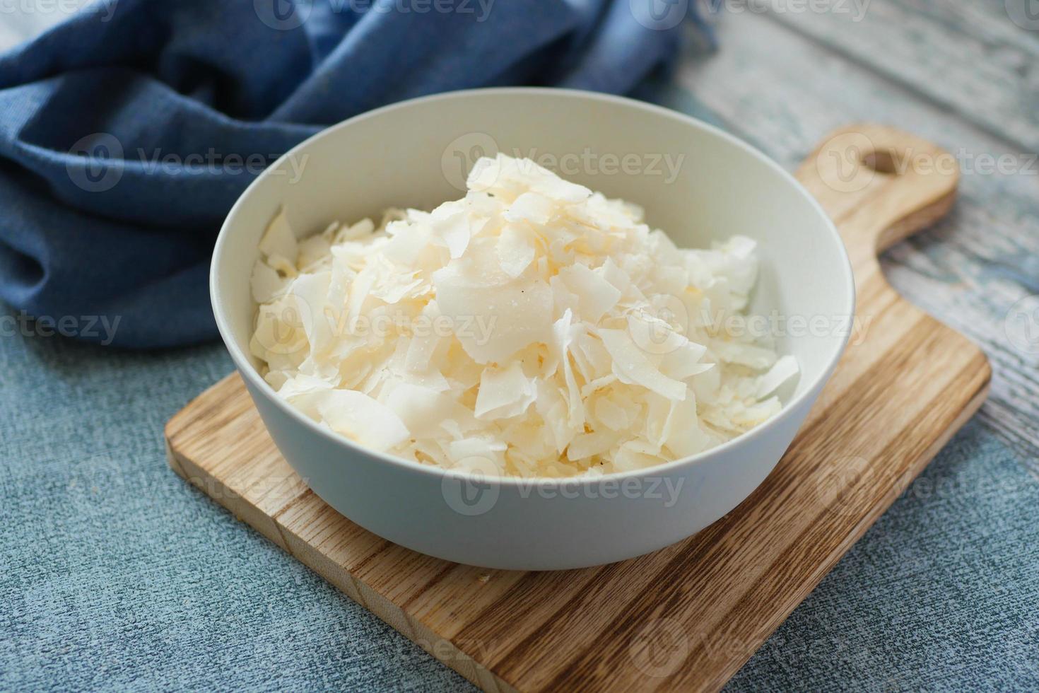 slice of fresh coconut flakes in a bowl on a table photo