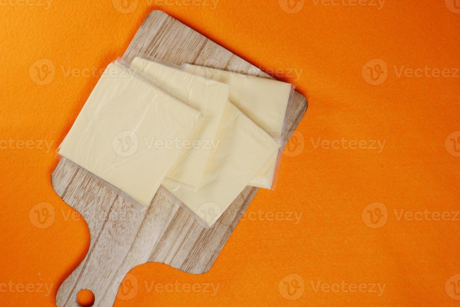 Transparent packet with slices of cheese on yellow , photo