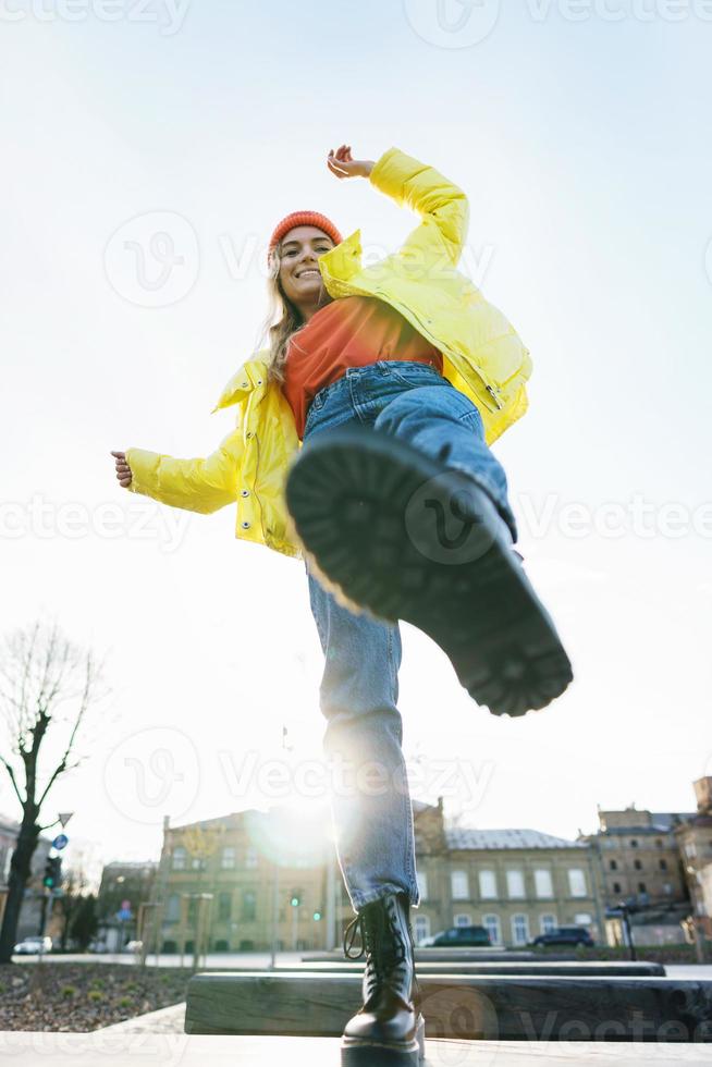 Stylish girl wearing yellow puffer and orange knitted hat photo