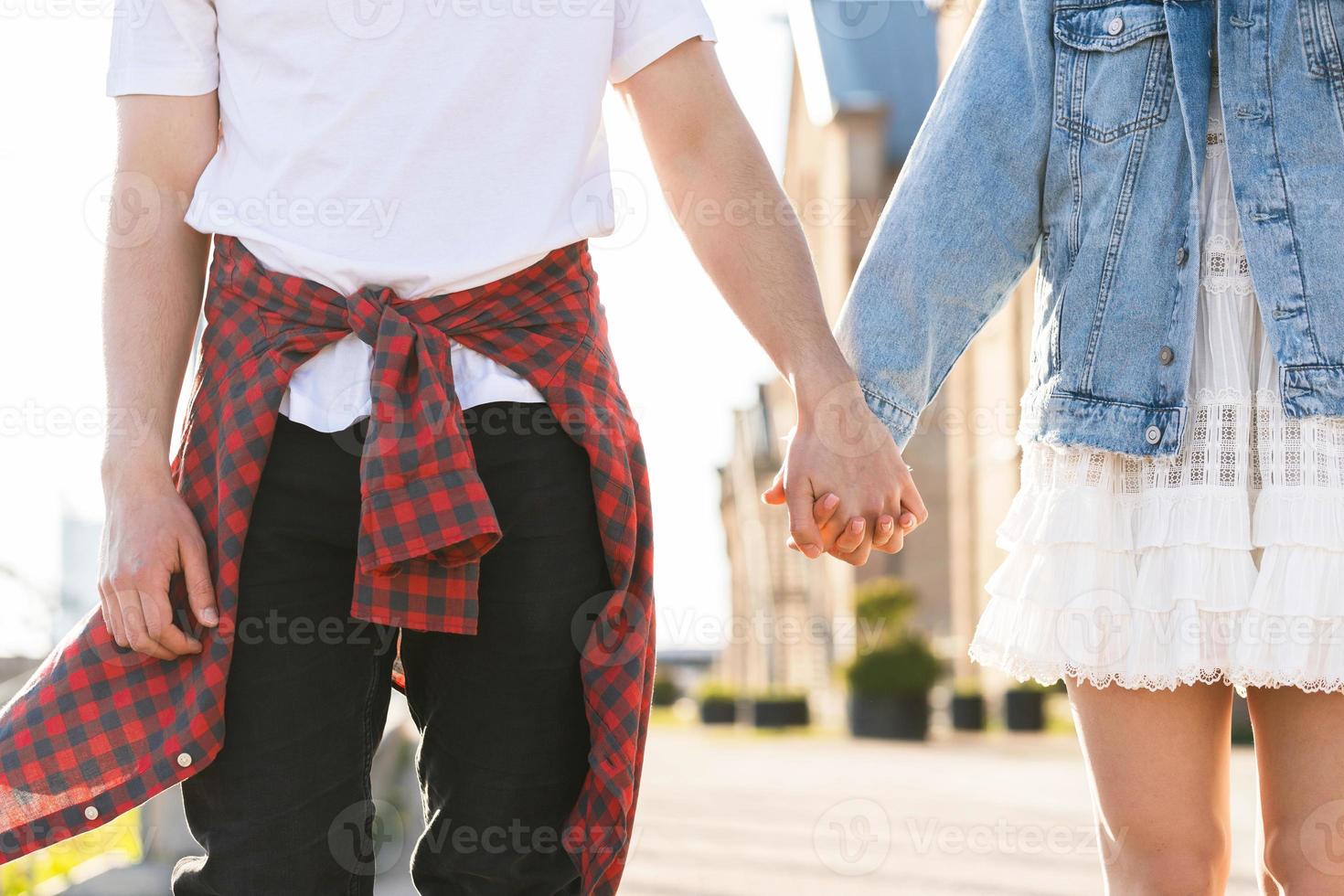 Young couple holding hands on a street photo