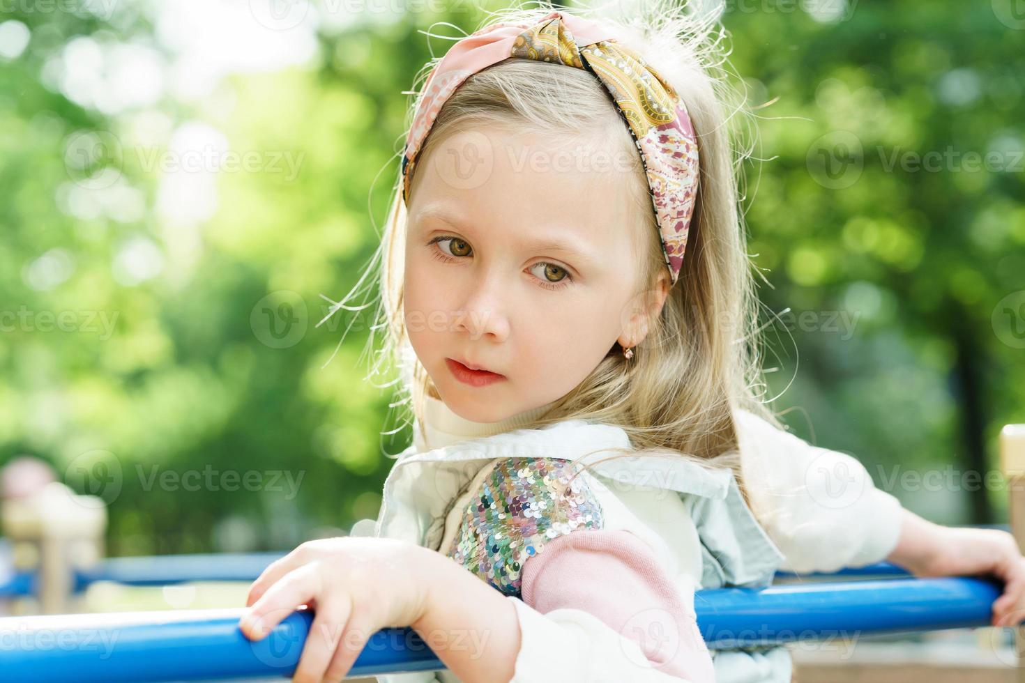 linda niña jugando en un patio de recreo en un parque de la ciudad foto