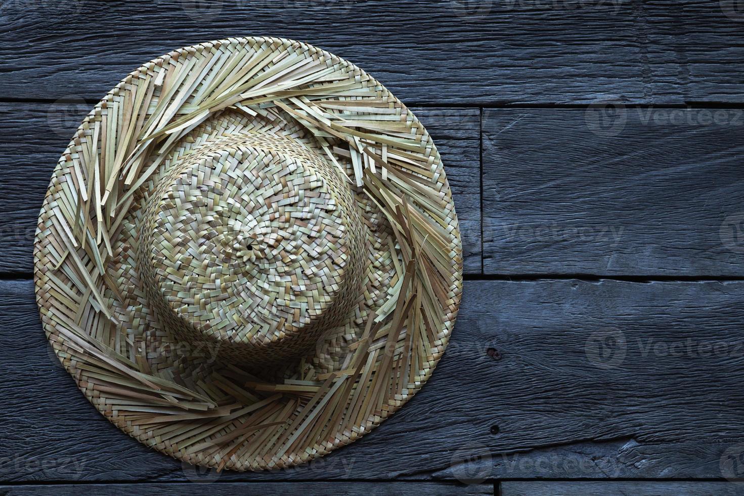 Straw hat against a old wooden surface photo