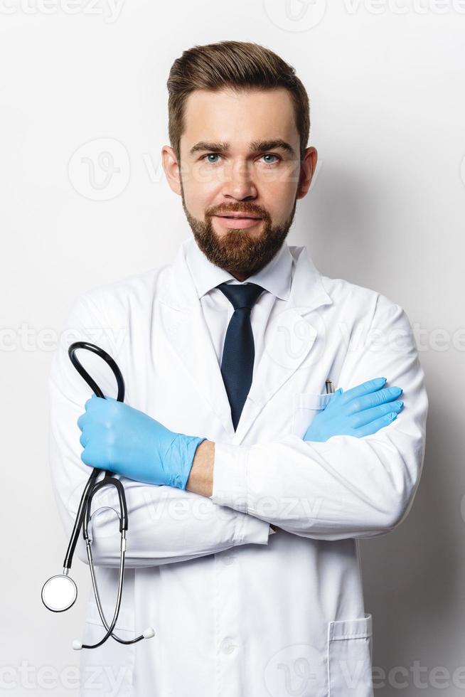médico con el estetoscopio sobre fondo gris foto