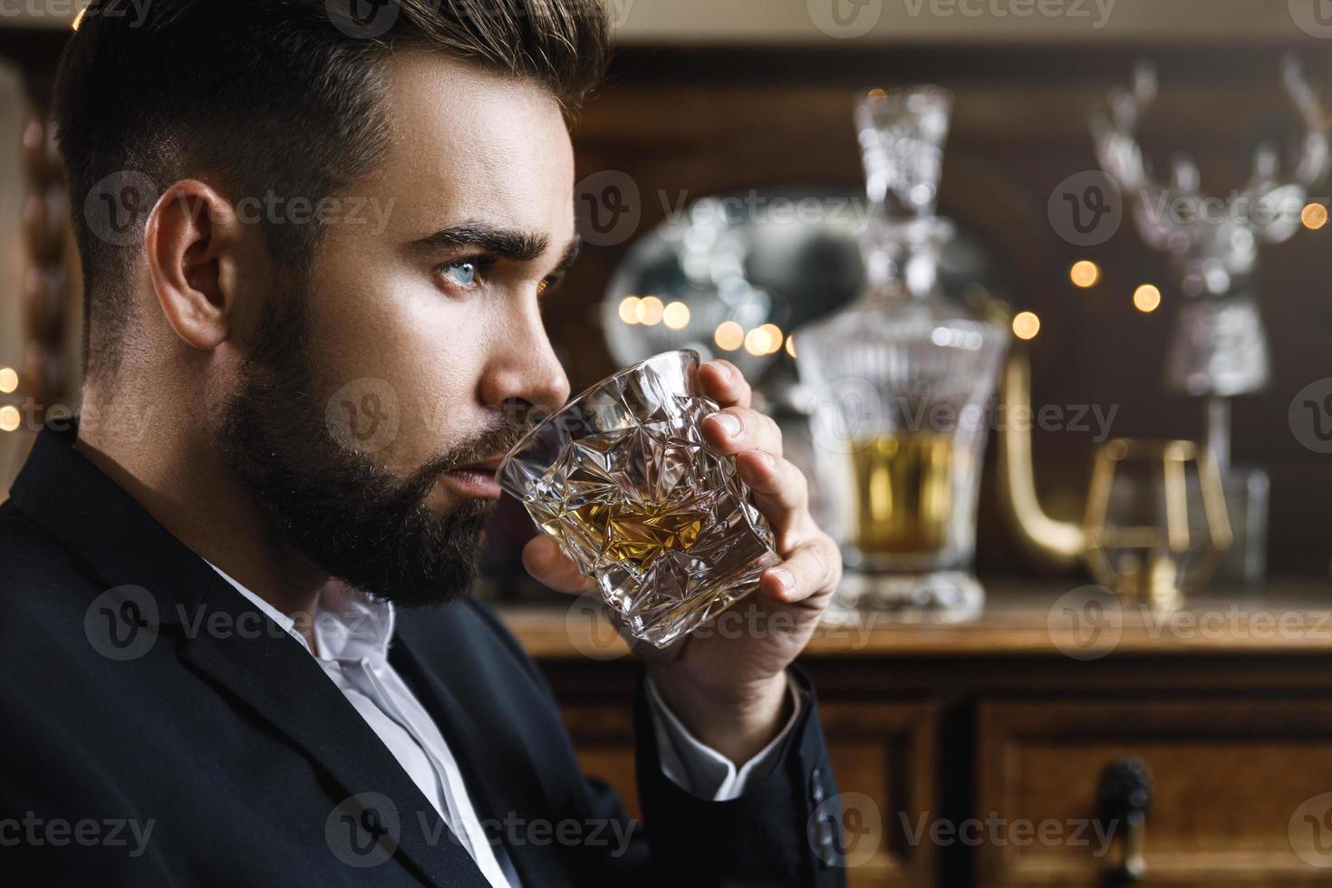 Handsome bearded man with a glass of whiskey photo