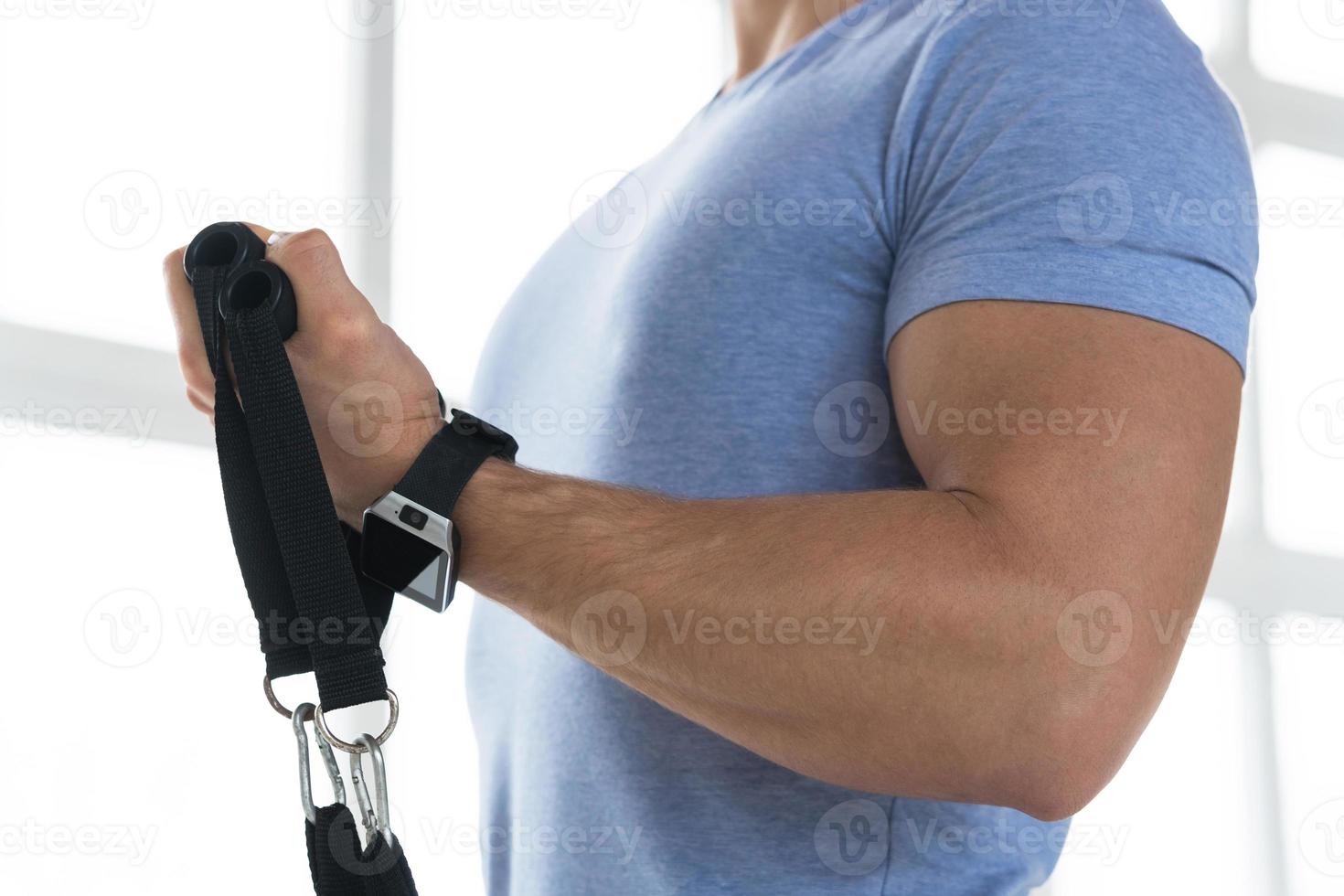 Young man during workout with a resistance bands in the gym photo