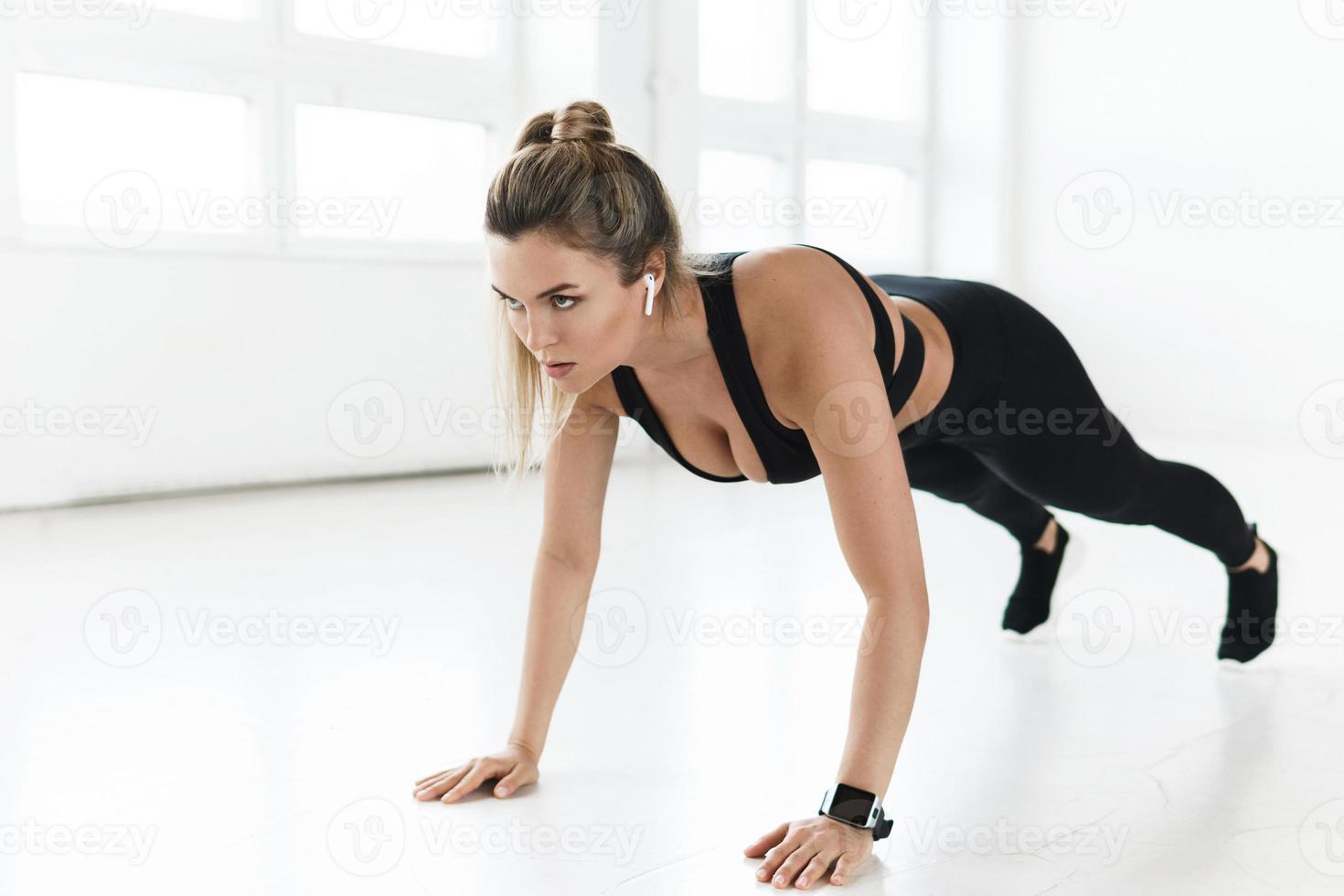 Woman doing push-ups during calisthenic workout in the gym photo