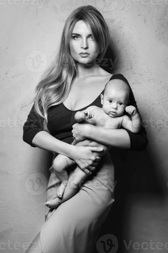 Beautiful well dressed mother with her cute baby in her hands photo