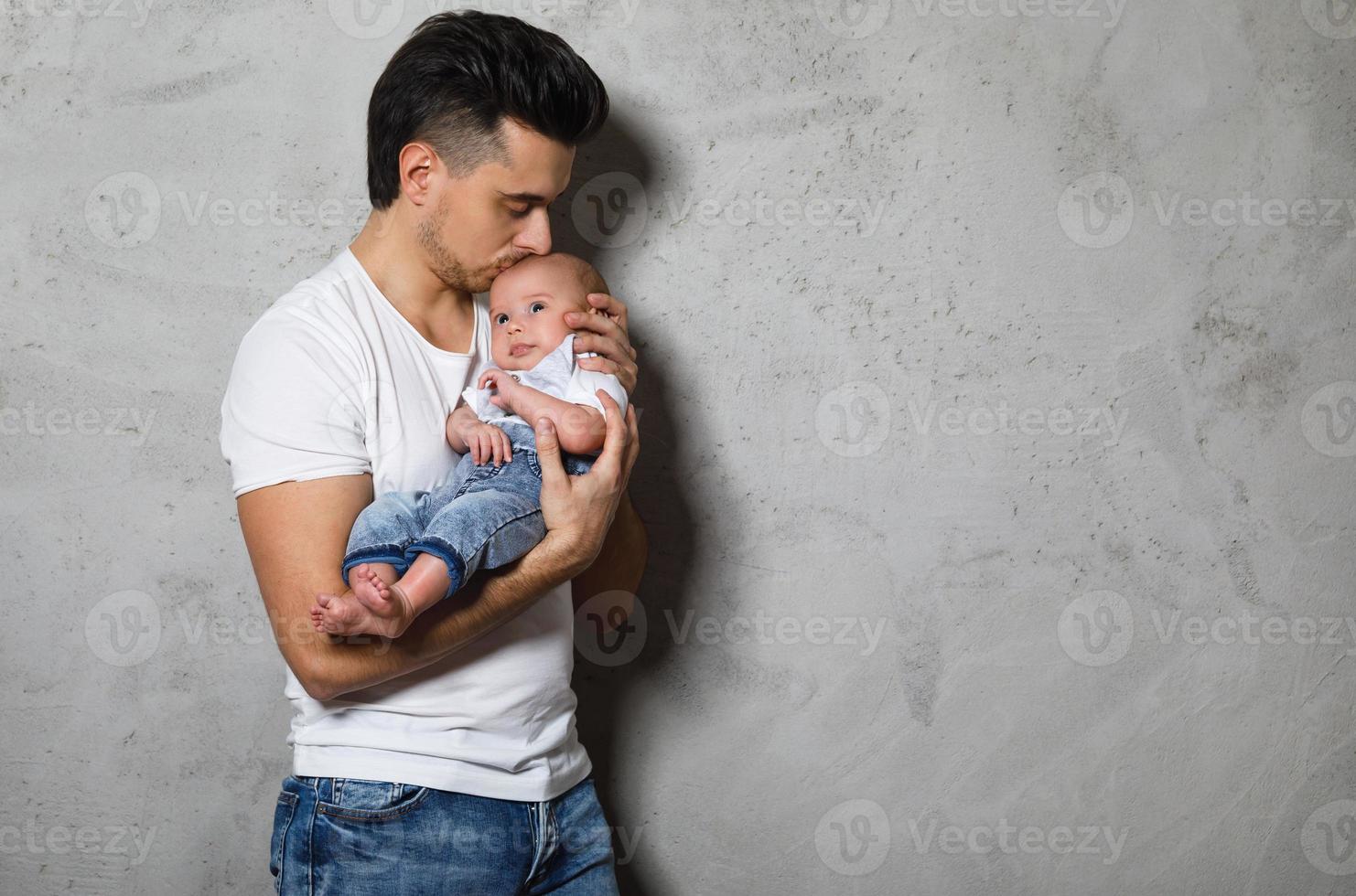joven padre besa a su lindo bebé foto